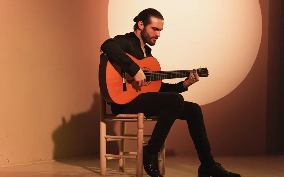 A seated guitarist at Centro Cultural Flamenco