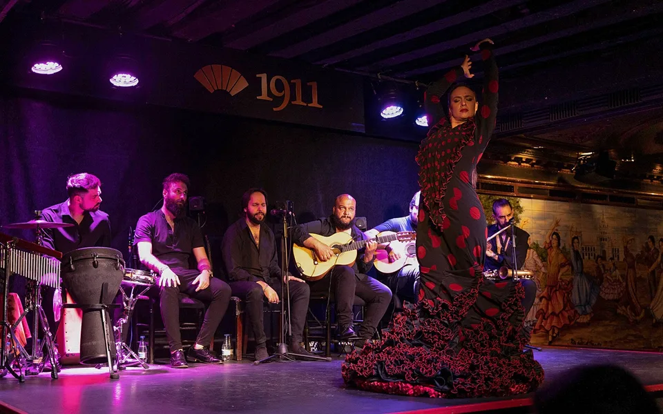 Un bailarín y músicos en el escenario del Tablao Flamenco 1911